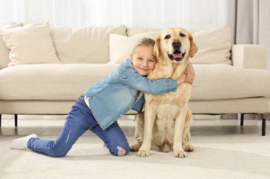 Evde Labrador Retriever 'ına sarılan sevimli çocuk. Sevimli hayvan.