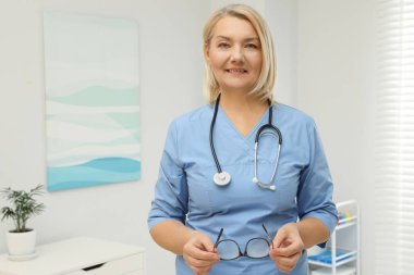 Klinikte üniforma giyen profesyonel doktorun portresi.