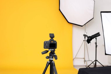 Modern fotoğraf stüdyosunda tripod ve profesyonel ışıklandırma ekipmanları var.