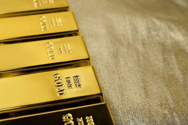 Parlak kumaş üzerinde bir sürü altın külçe, yakın plan. Metin için boşluk