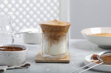 Lezzetli dalgona kahve ve açık gri masadaki malzemeler.