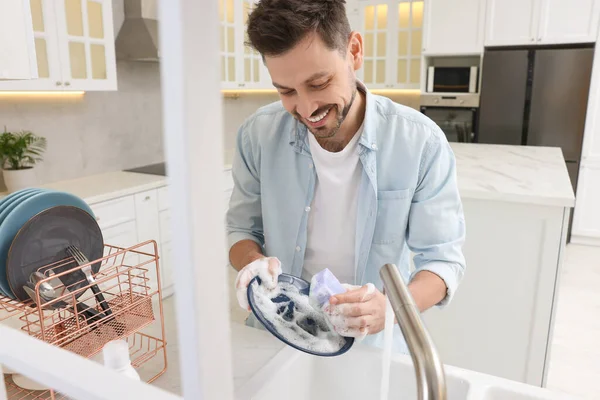 Mann Wäscht Teller Über Spüle Küche Blick Von Außen — Stockfoto