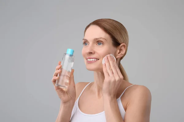 Vacker Kvinna Tar Bort Makeup Med Bomullspad Grå Bakgrund — Stockfoto