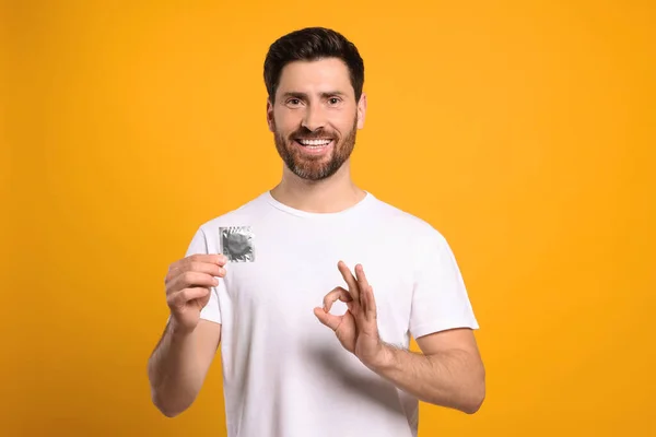Happy Man Condom Showing Gesture Yellow Background Safe Sex — Stock Photo, Image