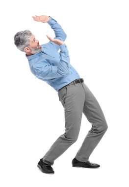 Şık giyinmiş olgun bir iş adamı beyaz arka plandaki bir şeyden kaçıyor.