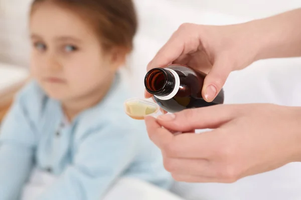Mother Pouring Cough Syrup Measuring Spoon Her Daughter Indoors Focus — Stock Photo, Image