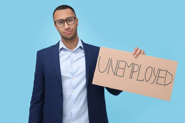 拿着标语牌 浅蓝色背景失业的年轻人 — 图库照片