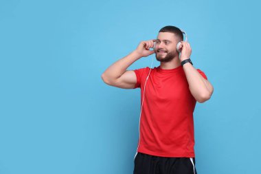 Açık mavi arka planda kulaklıklı yakışıklı bir adam, mesaj için yer