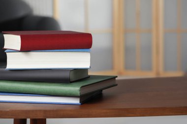 İçerideki ahşap sehpada kitap yığını, metin için yer.