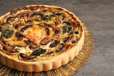 Koyu gri masada mantarlı nefis kiş, yakın plan.