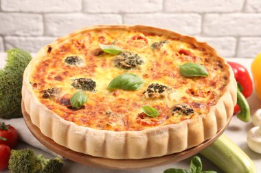 Lezzetli ev yapımı sebzeli kiş ve malzemeler masada.