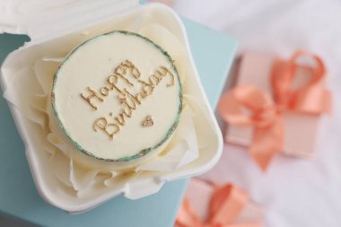 Açık mavi yüzeyde nefis dekore edilmiş doğum günü pastası, üst manzara. Metin için boşluk