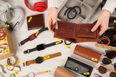 Masanın yanında cüzdanı olan bir kadın. Garaj satışı