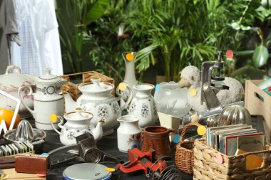 İçerideki siyah ahşap masada bir sürü farklı şey var. Garaj satışı