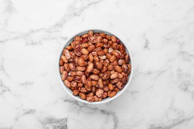 Beyaz mermer masada kuru fasulyeli kase, üst manzara.