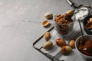 Gri masadaki konsantre sütle birlikte lezzetli ceviz şeklinde kurabiyeler. Metin için boşluk