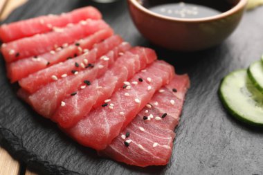 Lezzetli sashimi (susam tohumlu taze ton balığı parçaları) siyah tahtada, yakın plan