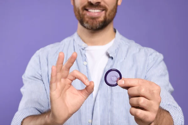 Homem Com Preservativo Mostrando Gesto Fundo Roxo Close Sexo Seguro — Fotografia de Stock