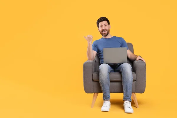 Homem Emocional Com Laptop Sentado Poltrona Contra Fundo Amarelo Espaço — Fotografia de Stock