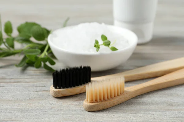 Toothbrushes Salt Green Herbs Wooden Table Closeup — Stock Photo, Image