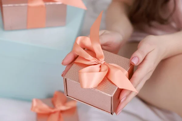 Woman with gift box indoors, closeup view