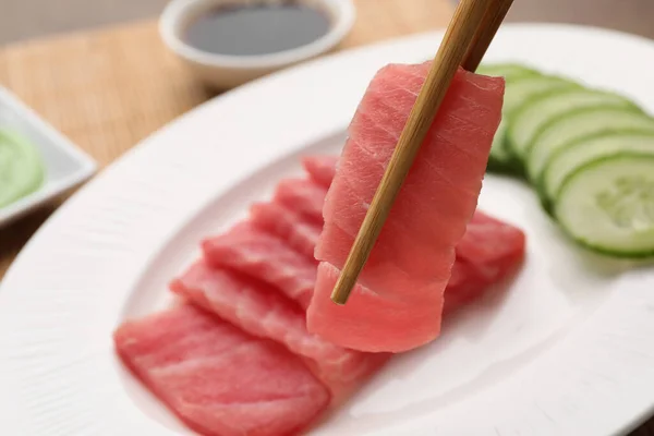Segurando Saboroso Sashimi Pedaço Atum Cru Fresco Com Pauzinhos Contra — Fotografia de Stock