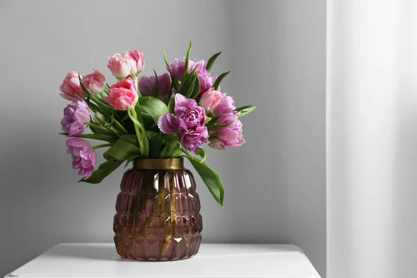 Piękny Bukiet Kolorowych Kwiatów Tulipanów Białym Stole Pobliżu Jasnoszarej Ściany — Zdjęcie stockowe
