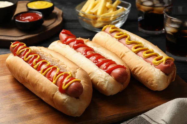 Deliciosos Cachorros Quentes Com Mostarda Ketchup Mesa Madeira Preta Close — Fotografia de Stock