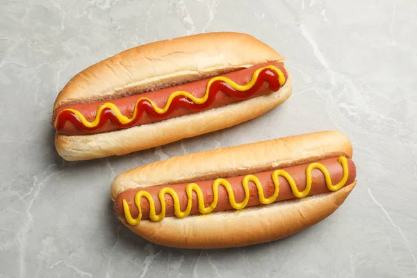 Pyszne Hot Dogi Musztardą Ketchupem Jasnoszary Stół Płaskie Układanki — Zdjęcie stockowe