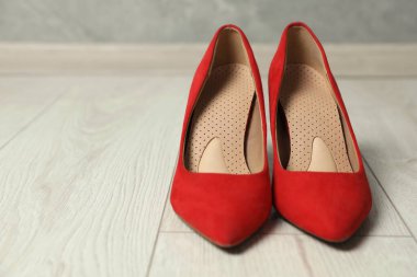 Yerdeki yüksek topuklu ayakkabılarla ortopedik tabanlar, yakın plan. Metin için boşluk