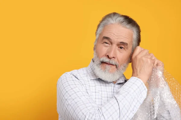 Uomo Anziano Emotivo Popping Involucro Bolla Sfondo Giallo Spazio Testo — Foto Stock
