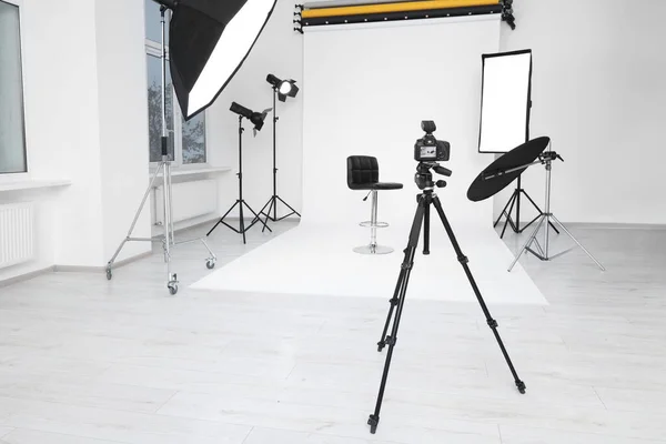 現代のフォトスタジオで三脚 バースツールやプロの照明機器上のカメラ — ストック写真