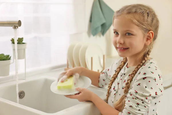 Ευτυχισμένο Κορίτσι Πλύσιμο Πιάτο Πάνω Από Νεροχύτη Στην Κουζίνα — Φωτογραφία Αρχείου