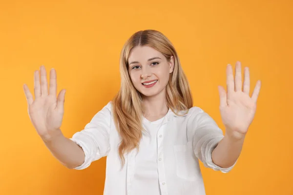 Счастливая Женщина Дает Пять Обеими Руками Оранжевом Фоне — стоковое фото