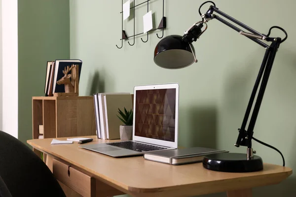 Modern Laptop Books Lamp Stationery Wooden Desk Green Wall Home — Zdjęcie stockowe