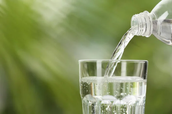 Water Uit Fles Gieten Glas Wazig Groene Achtergrond Close Ruimte — Stockfoto