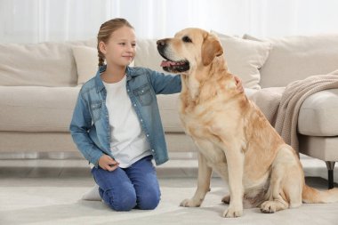 Evde yerde Labrador Retriever 'ı olan sevimli bir çocuk. Sevimli hayvan.