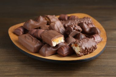 Tasty chocolate bars on wooden table, closeup