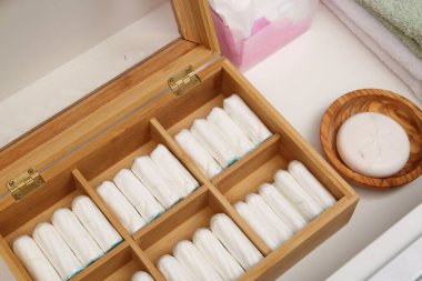 Tamponların ve farklı hijyen ürünlerinin depolanması beyaz çekmecede, yakın plan.