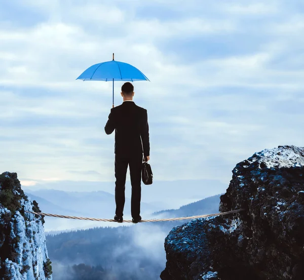 创业的风险和挑战 带着投资组合和雨伞 站在高山的深渊之上 后视镜 — 图库照片