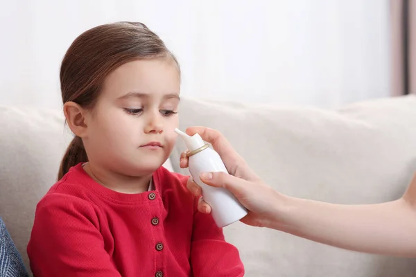 Mother Using Nasal Spray Treat Her Little Daughter Sofa Indoors — Stock Photo, Image