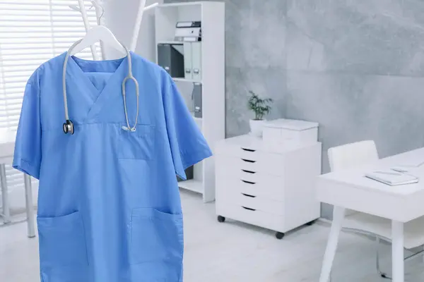 Niebieski Mundur Medyczny Stetoskop Wiszą Wieszaku Klinice Miejsce Tekst — Zdjęcie stockowe