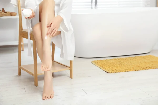 Młoda Kobieta Nakładająca Krem Ciała Nogę Łazience Zbliżenie Miejsce Tekst — Zdjęcie stockowe