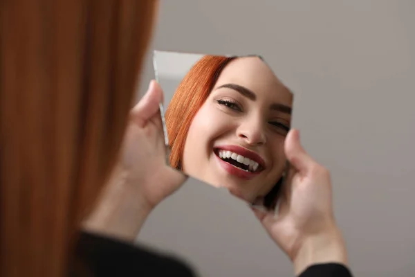 Lächelnde Junge Frau Die Sich Zerbrochenen Spiegel Auf Hellgrauem Hintergrund — Stockfoto