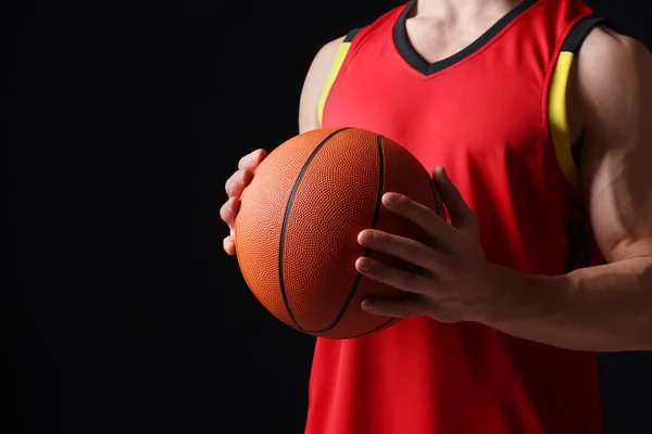 黒の背景にバスケットボールボールを持つアスレチックマン クローズアップ テキストのスペース — ストック写真