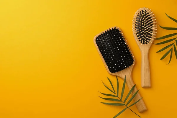Wooden Hairbrushes Green Leaves Orange Background Flat Lay Space Text — Stock Photo, Image