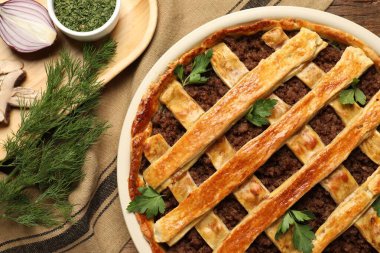 Taze pişmiş etli turta ve masada duran ürünler.