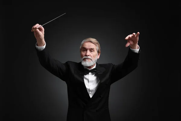 stock image Professional conductor with baton on black background