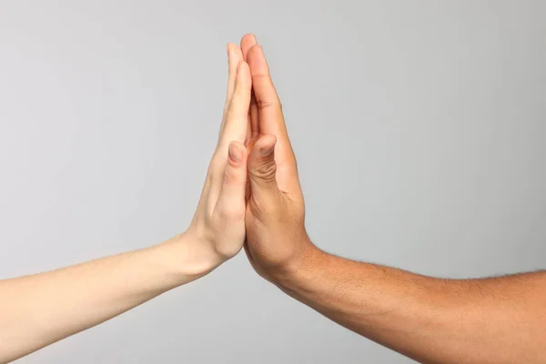 stock image International relationships. People giving high five on light grey background, closeup