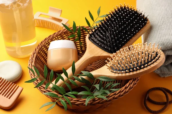 stock image Wooden brushes and different hair products on orange background